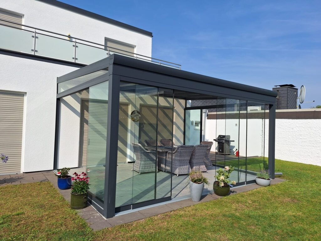 Moderne Terrassenüberdachung mit Glasdach und Aluminiumkonstruktion an einem Einfamilienhaus