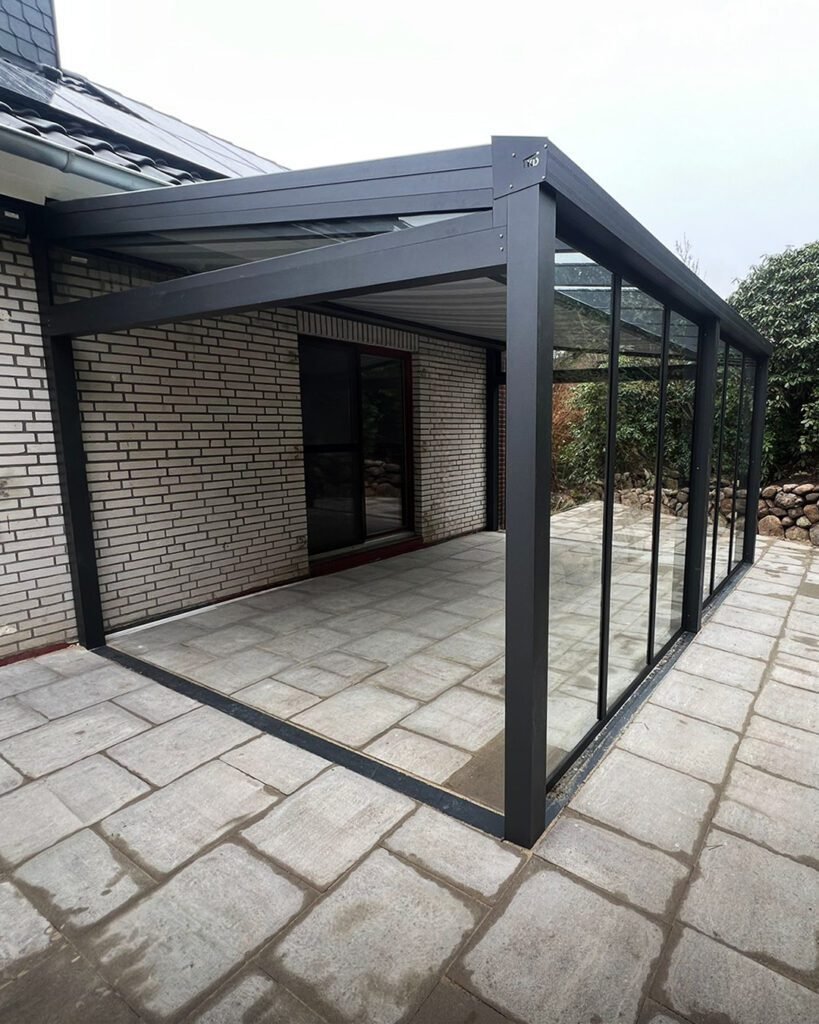 Moderner Wintergarten mit Aluminiumkonstruktion und großen Glasfenstern – ideale Terrassenüberdachung für mehr Wohnkomfort.