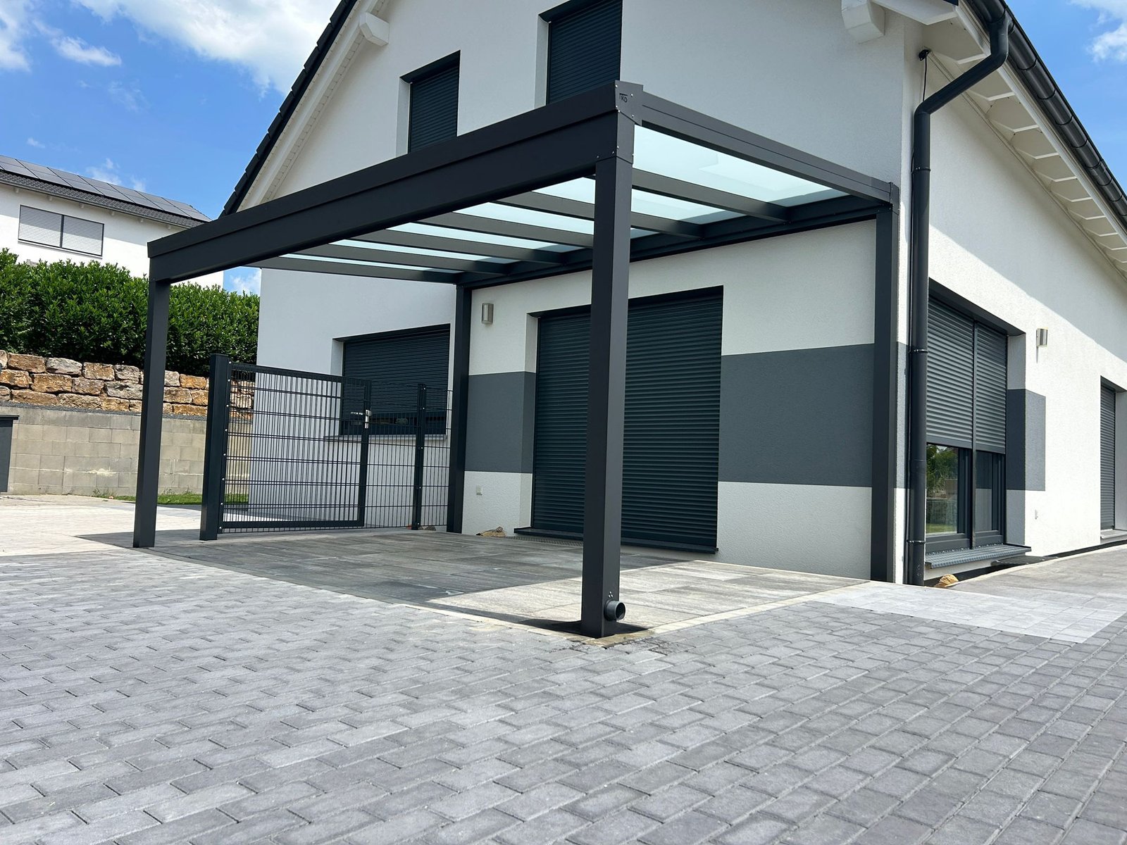 Haus in Leverkusen mit moderner Terrassenüberdachung, großen Fenstern und integrierten Rolladen