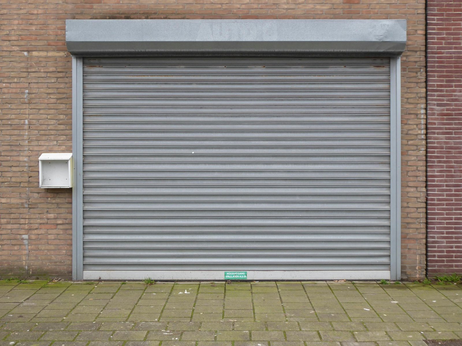 Geschlossene graue Rollladen-Tür an moderner Fassade – idealer Sicht- und Einbruchschutz