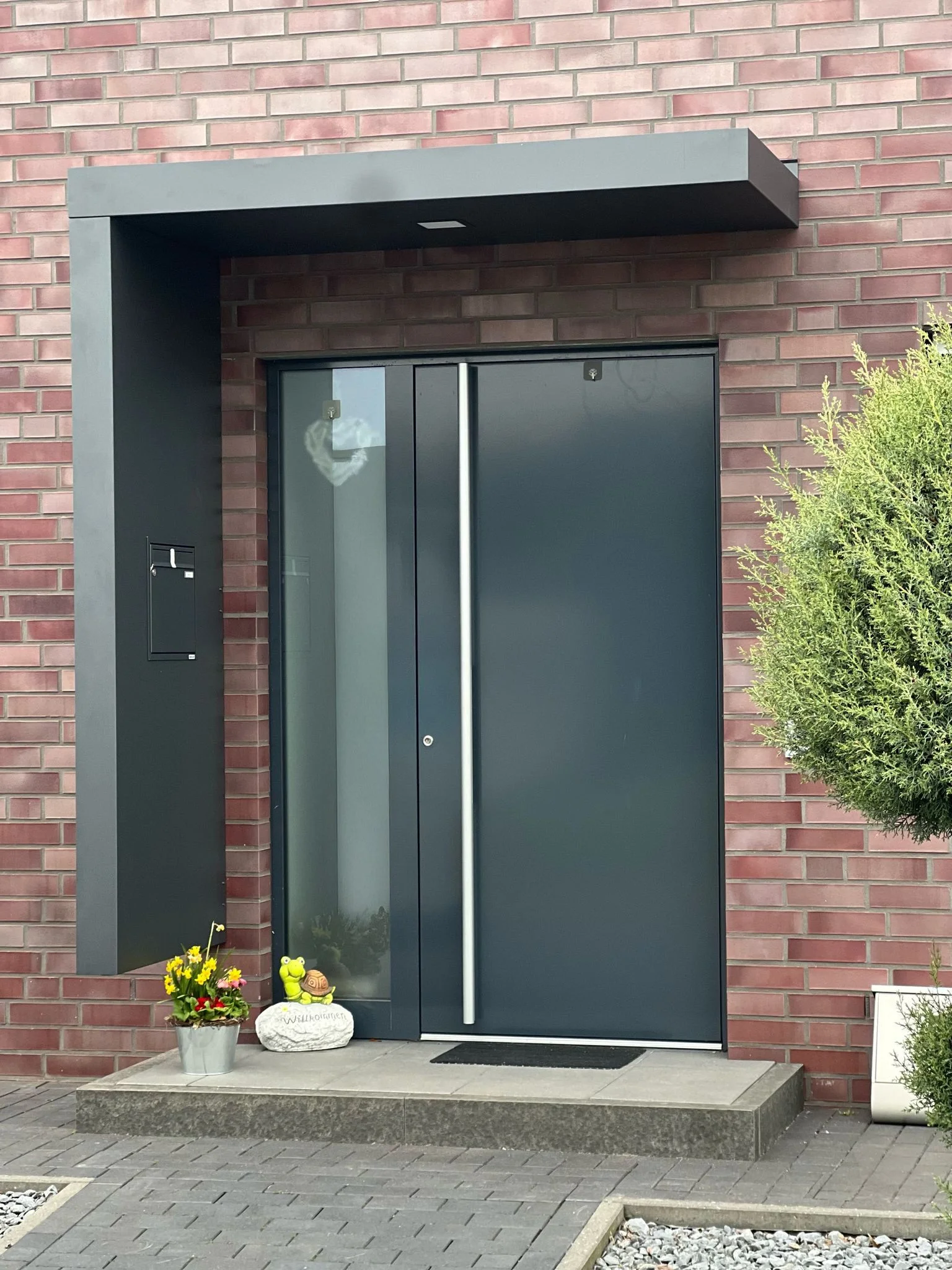 Moderne anthrazitfarbene Aluminium Haustür mit Seitenteil und Edelstahl-Applikationen in Köln