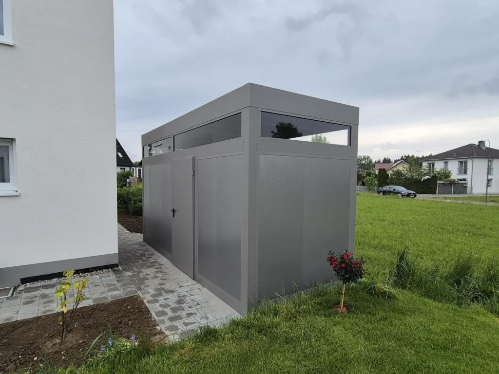 Länglicher, schmaler Geräteschuppen aus Aluminium in Anthrazit mit Oberlicht, ideal für schmale Gartenflächen in Langenfeld und Bergisch Gladbach