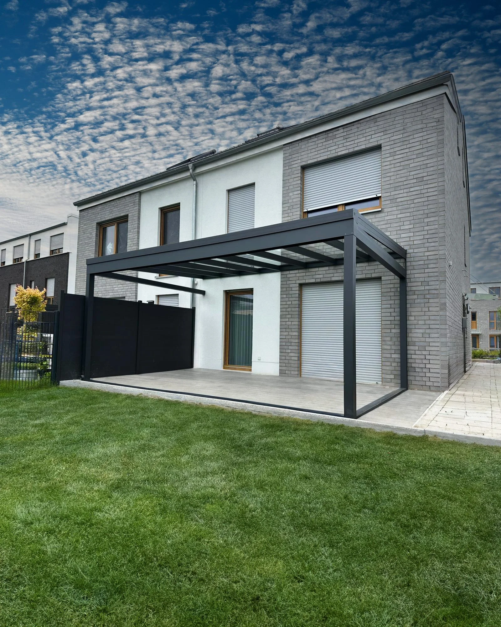 Moderne anthrazitfarbene Terrassenüberdachung mit fester Seitenwand als Sichtschutz, Montagebeispiel in Langenfeld und Bergisch Gladbach