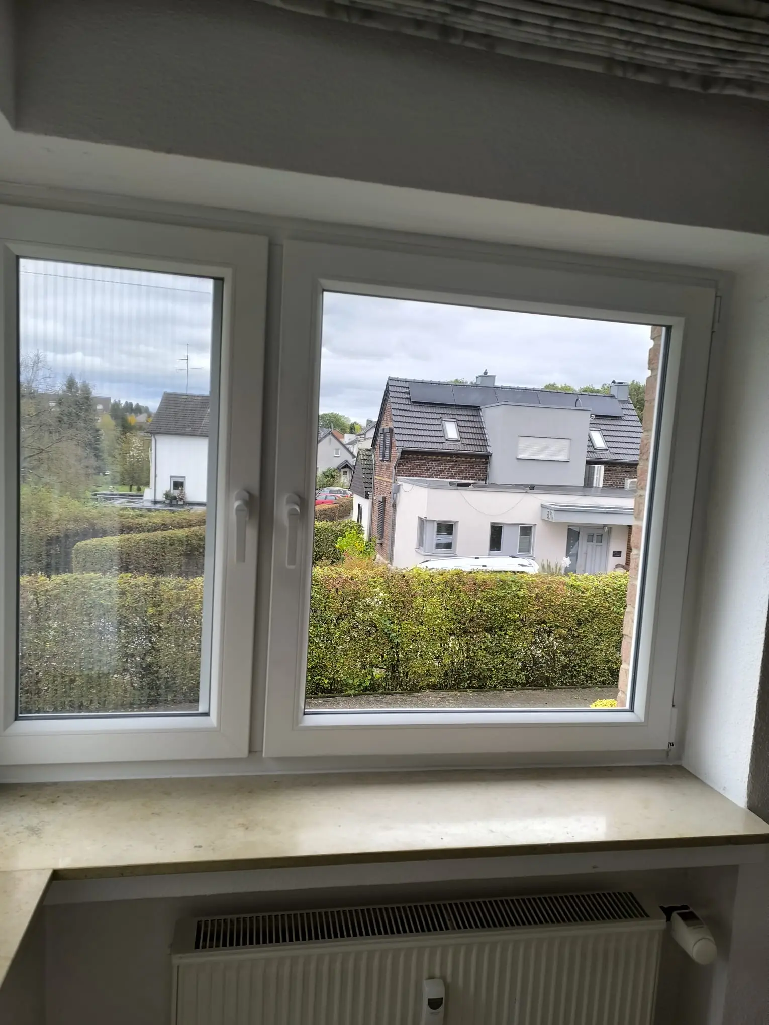 Zweiflügeliges weißes Kunststofffenster mit breiter Fensterbank - Professioneller Einbau durch Elsfen Bauelemente in Leverkusen