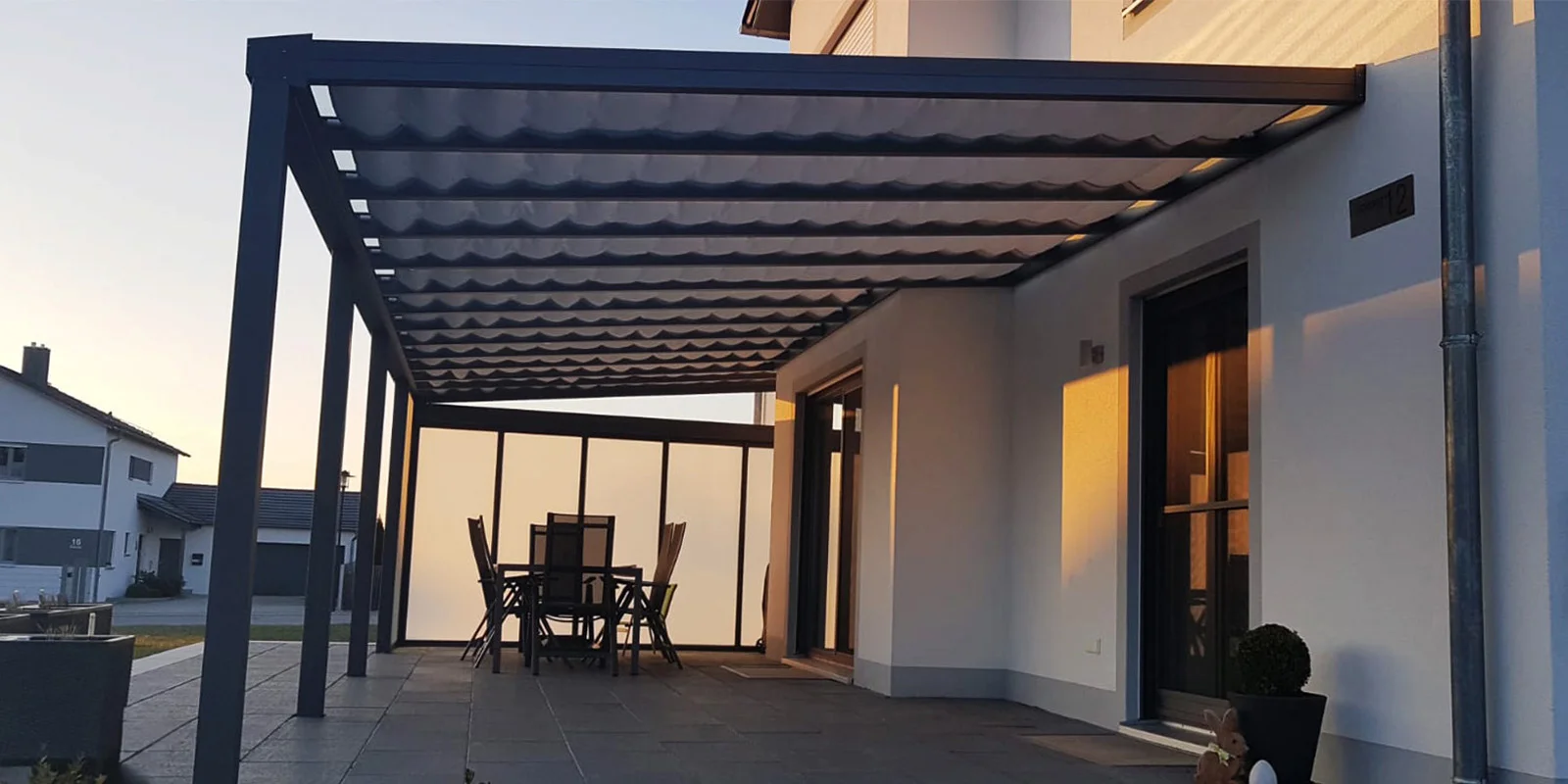 Aluminium-Terrassenüberdachung in Anthrazit mit Glasdach über dem Essbereich in Leverkusen