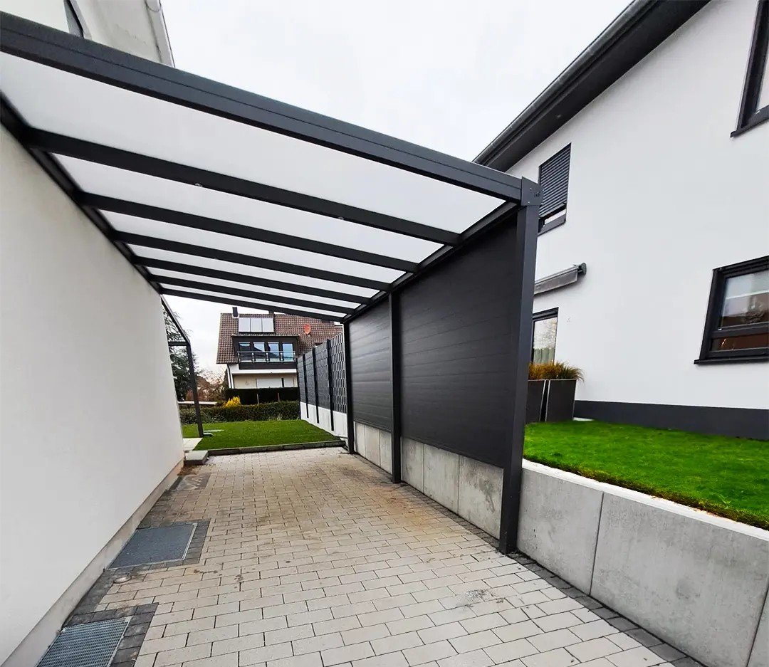 Anlehncarport aus Aluminium in Anthrazit an einer Ziegelfassade in Langenfeld