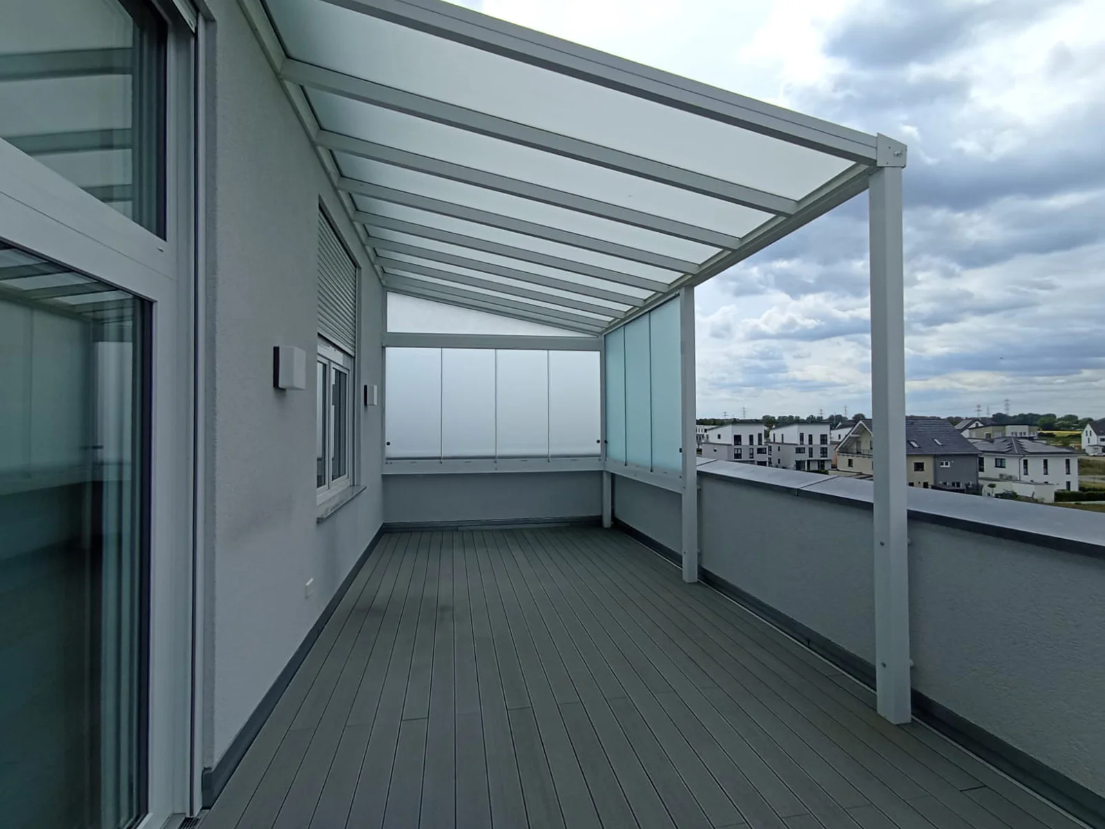 Balkonüberdachung mit weißem Glasdach auf einer Dachterrasse in Leverkusen