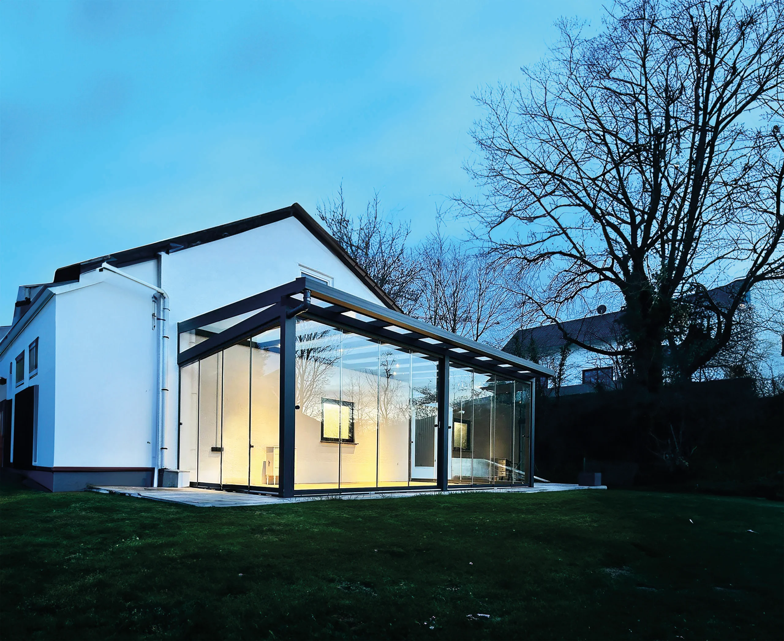 Beleuchteter Kaltwintergarten aus Aluminium und Glas bei Nacht in Solingen