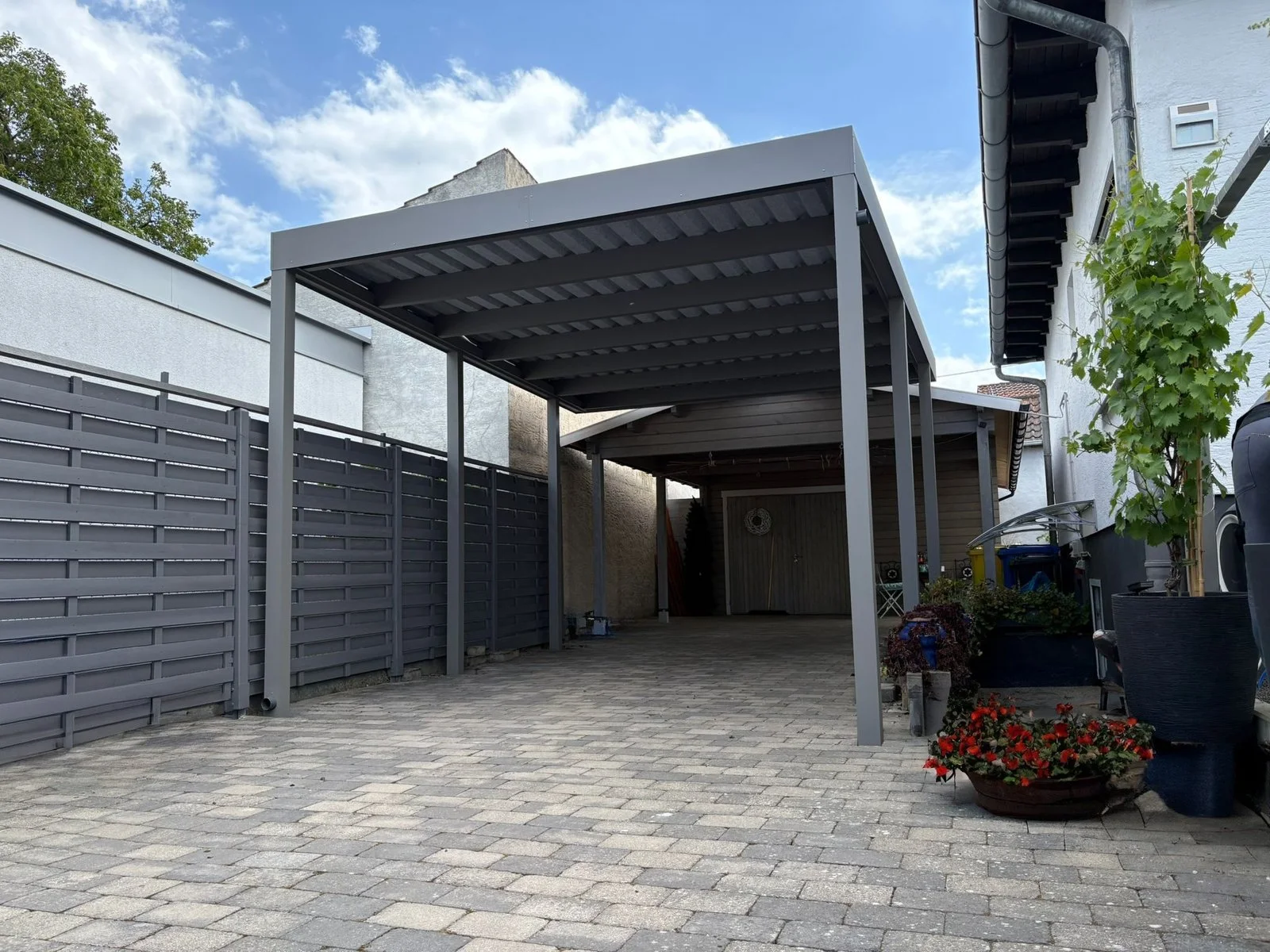 Aluminium-Carport in Silbergrau mit Sichtschutz, Außenansicht in Düsseldorf