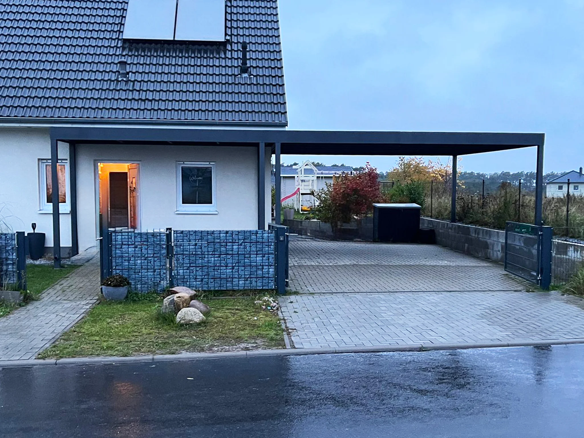 Carport mit Flachdach, Vordach und Gabionenzaun in Leverkusen