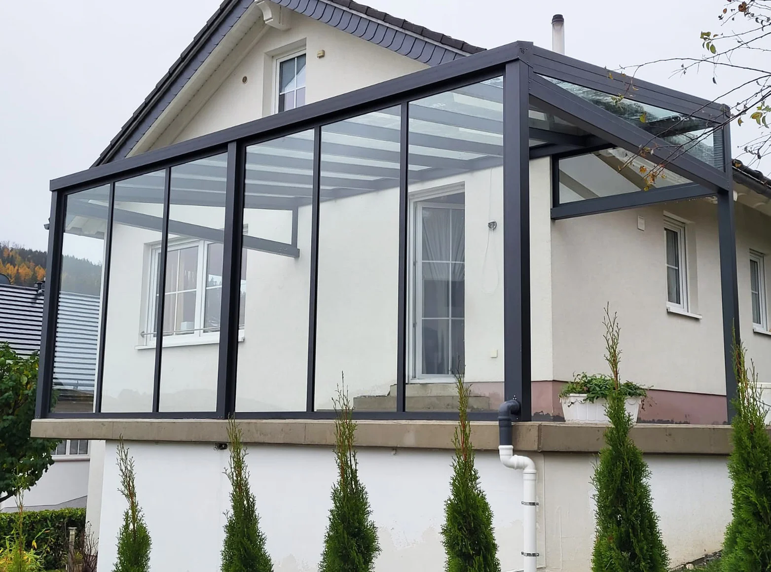 Kaltwintergarten aus Aluminium in Anthrazit auf einer erhöhten Terrasse in Leichlingen