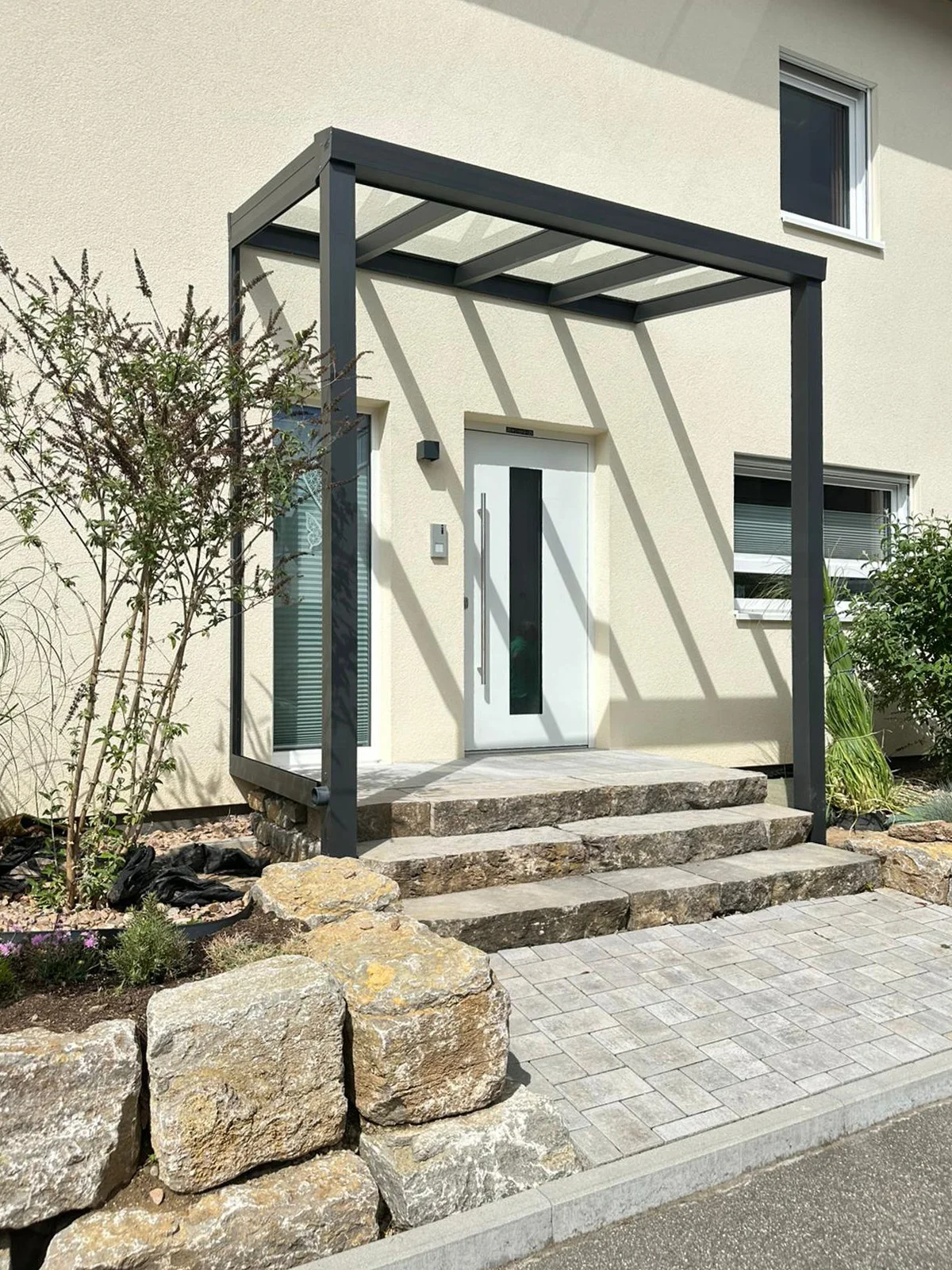 Aluminium-Vordach mit Glasdach über Natursteinstufen in Köln